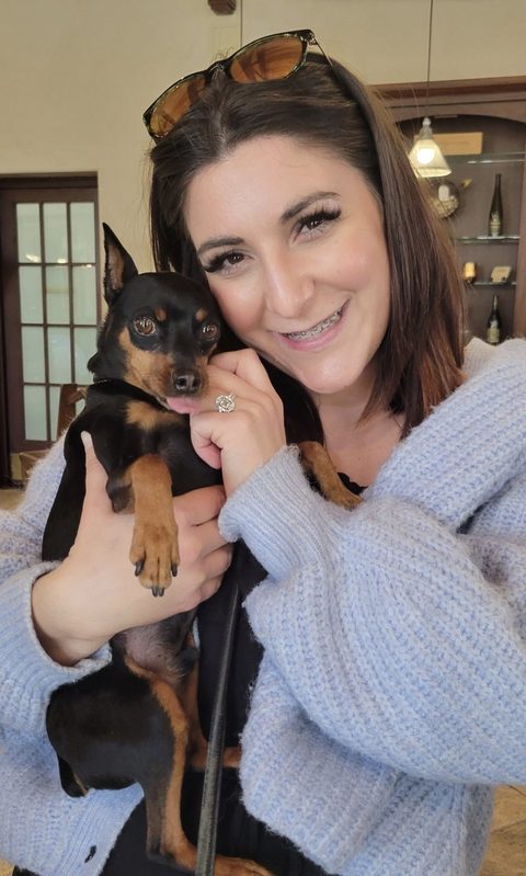 Alexis Moody cuddling a min pin client cheek to cheek
